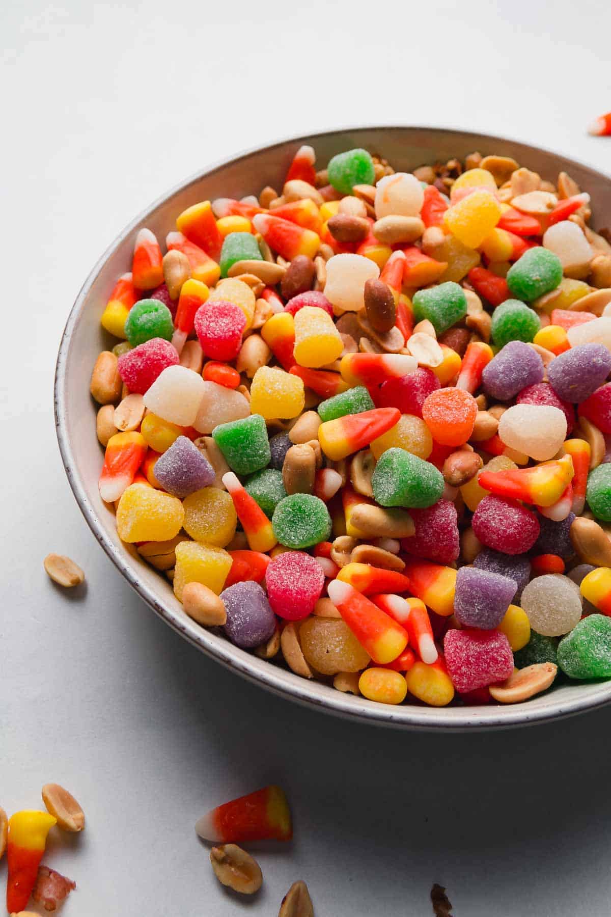 A bowl filled with a mix of colorful candy corn, gumdrops, and peanuts—a creative twist on classic Halloween food.