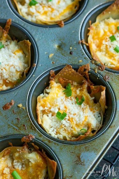 Muffin tin with crispy crack wonton cups filled with melted cheese and topped with chopped green onions.