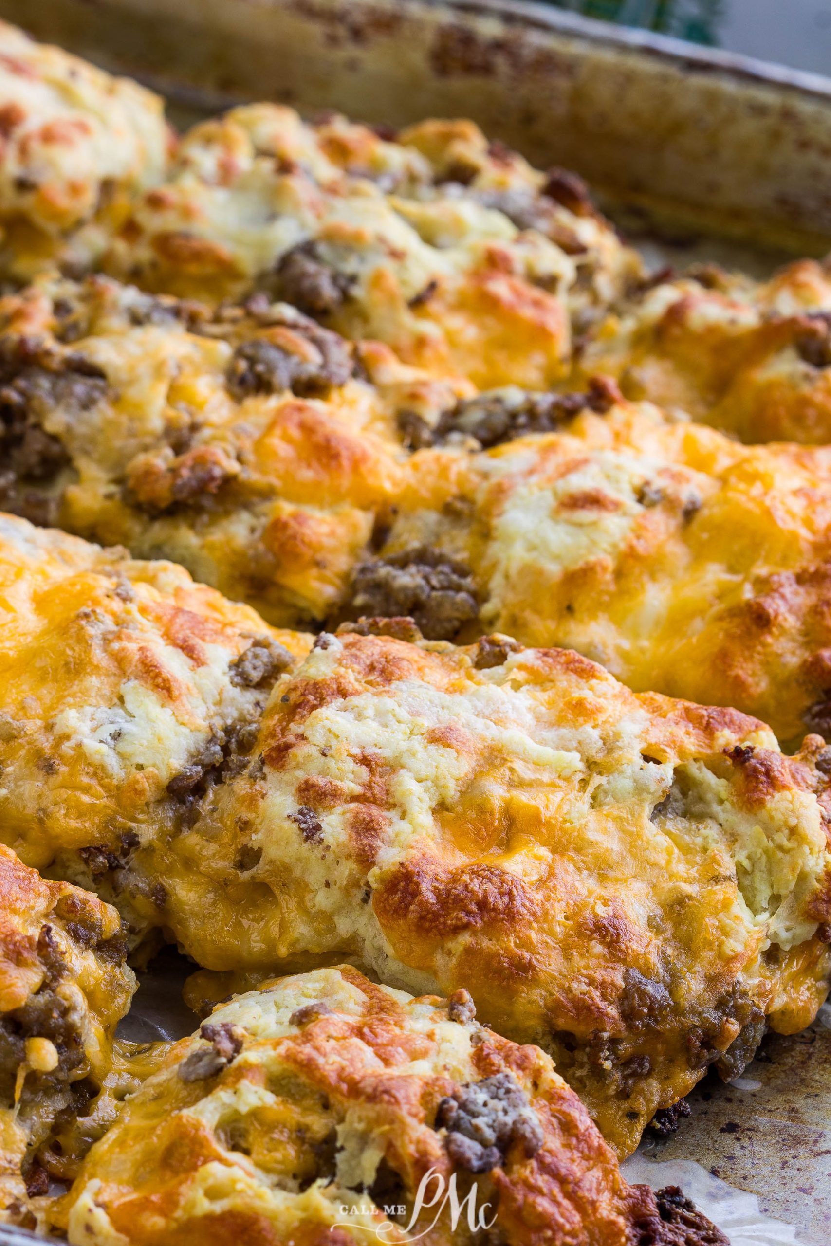 Homemade sausage cheddar biscuits with ground sausage on a metal tray.