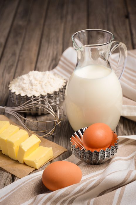 A jug of milk and eggs on a table.