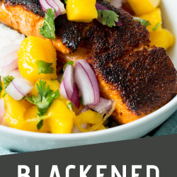 A plate of blackened salmon topped with mango salsa, featuring diced mango, red onions, and cilantro. Text on the image reads, "Blackened Salmon w/ Mango Salsa" with the website CallMePMc.com.