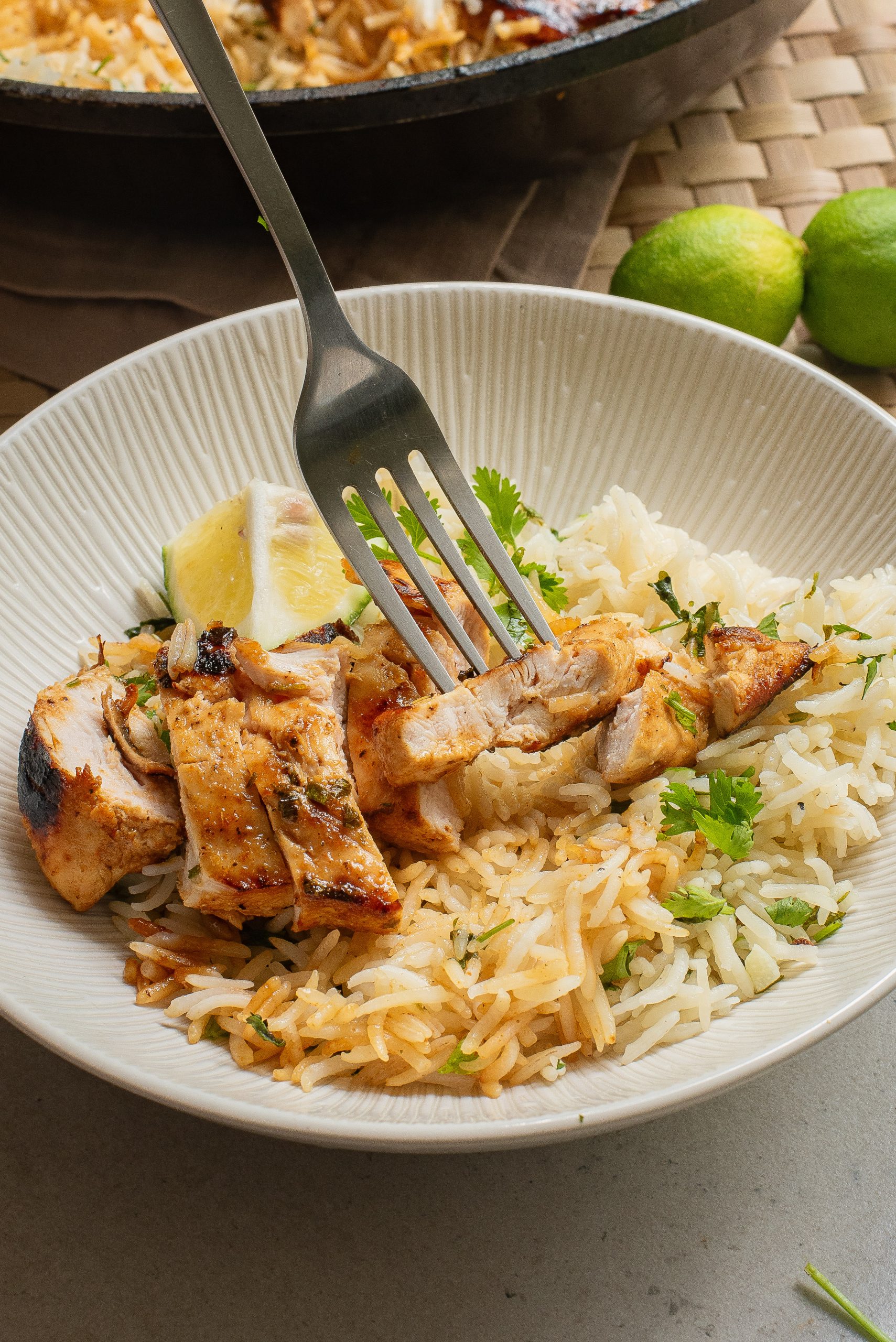 A fork in a plate with dinner on it.