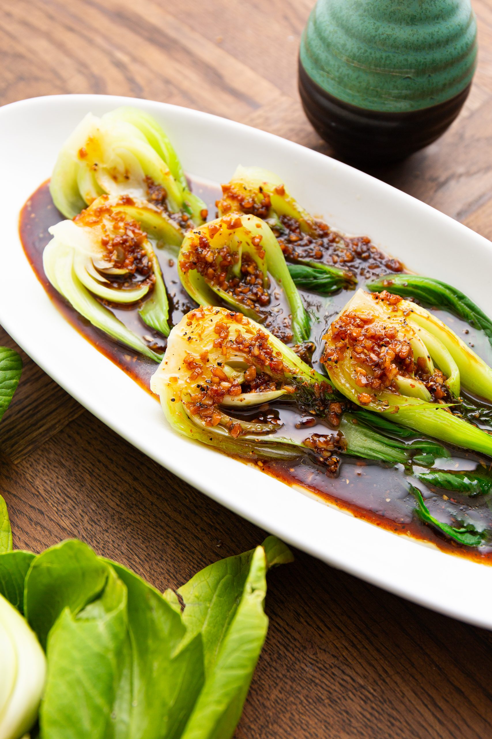 A white platter with green vegetables. 