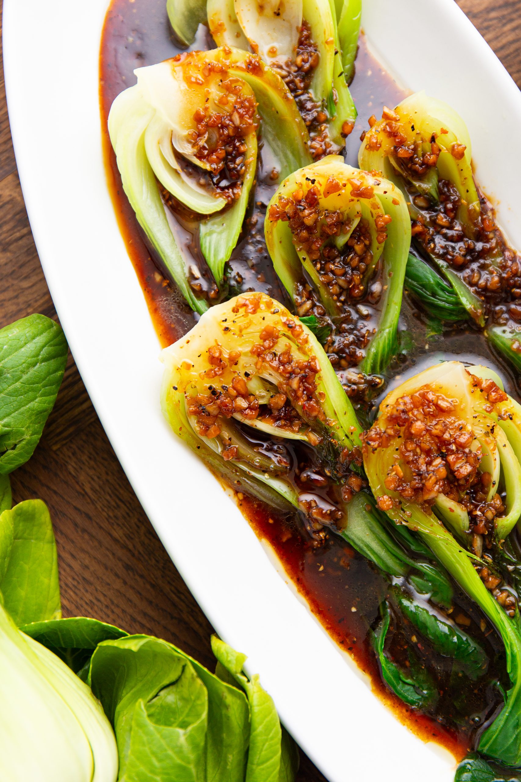 A plate of steamed vegetables, served on a wooden table.