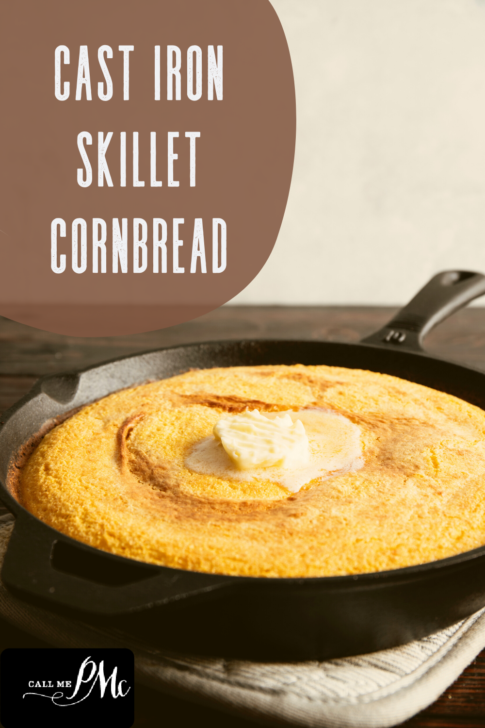 A cast iron skillet filled with freshly baked cornbread, topped with a dollop of butter. The text "Cast Iron Skillet Cornbread" appears on a brown background.