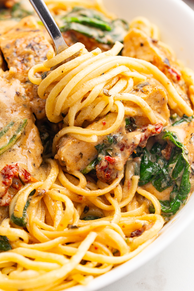 A close-up of a fork twirling spaghetti.