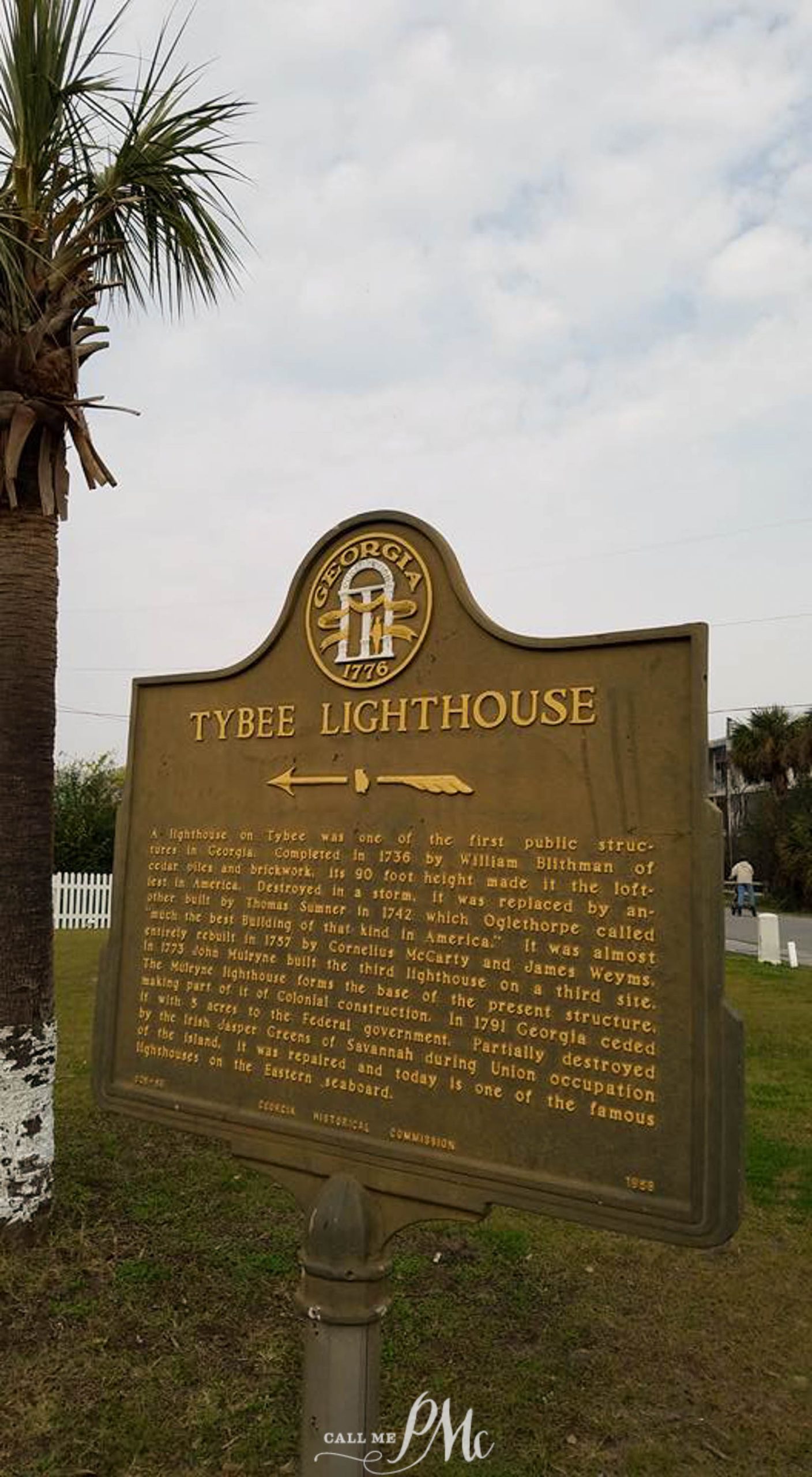 48 hours in Savannah. A historical marker sign for Tybee Lighthouse in Georgia, detailing its history and significance. The lighthouse is visible in the background along with some trees and a cloudy sky.