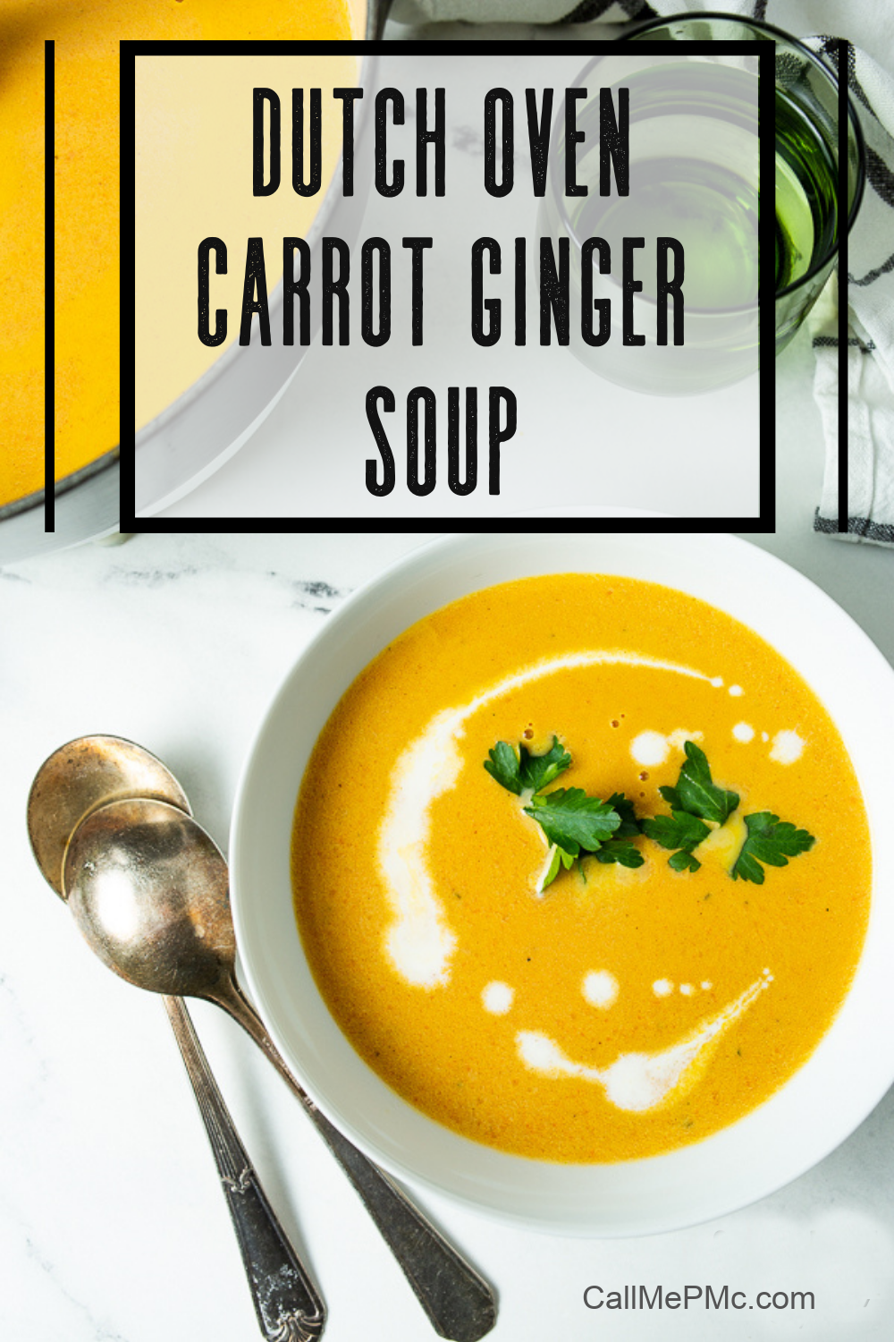 A bowl of Dutch Oven Carrot Ginger Soup garnished with parsley and cream, accompanied by two vintage spoons, seen on a white marble surface. Text overlay reads "Dutch Oven Carrot Ginger Soup.