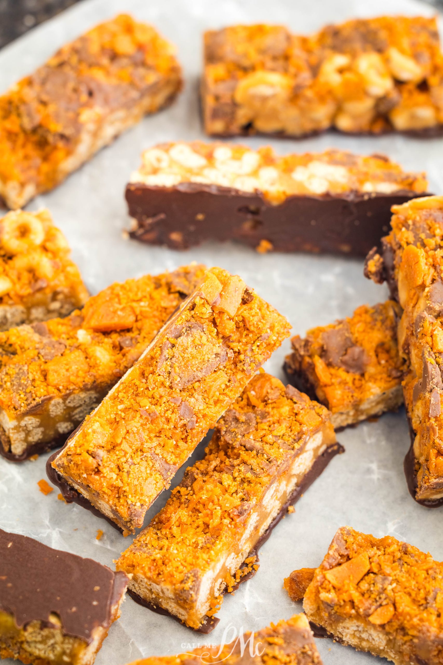 Several rectangular chocolate and honeycomb bars are arranged on a piece of parchment paper.