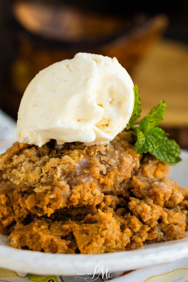 A scoop of vanilla ice cream atop a serving of spiced dessert with a mint garnish on a plate.