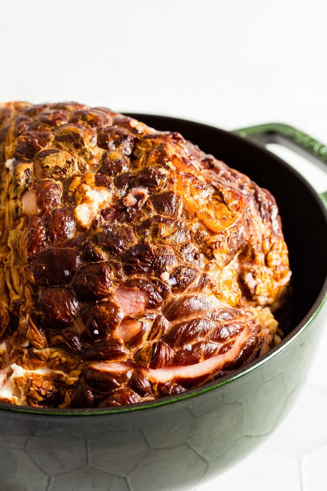 A large piece of cooked meat in a dark green pot.