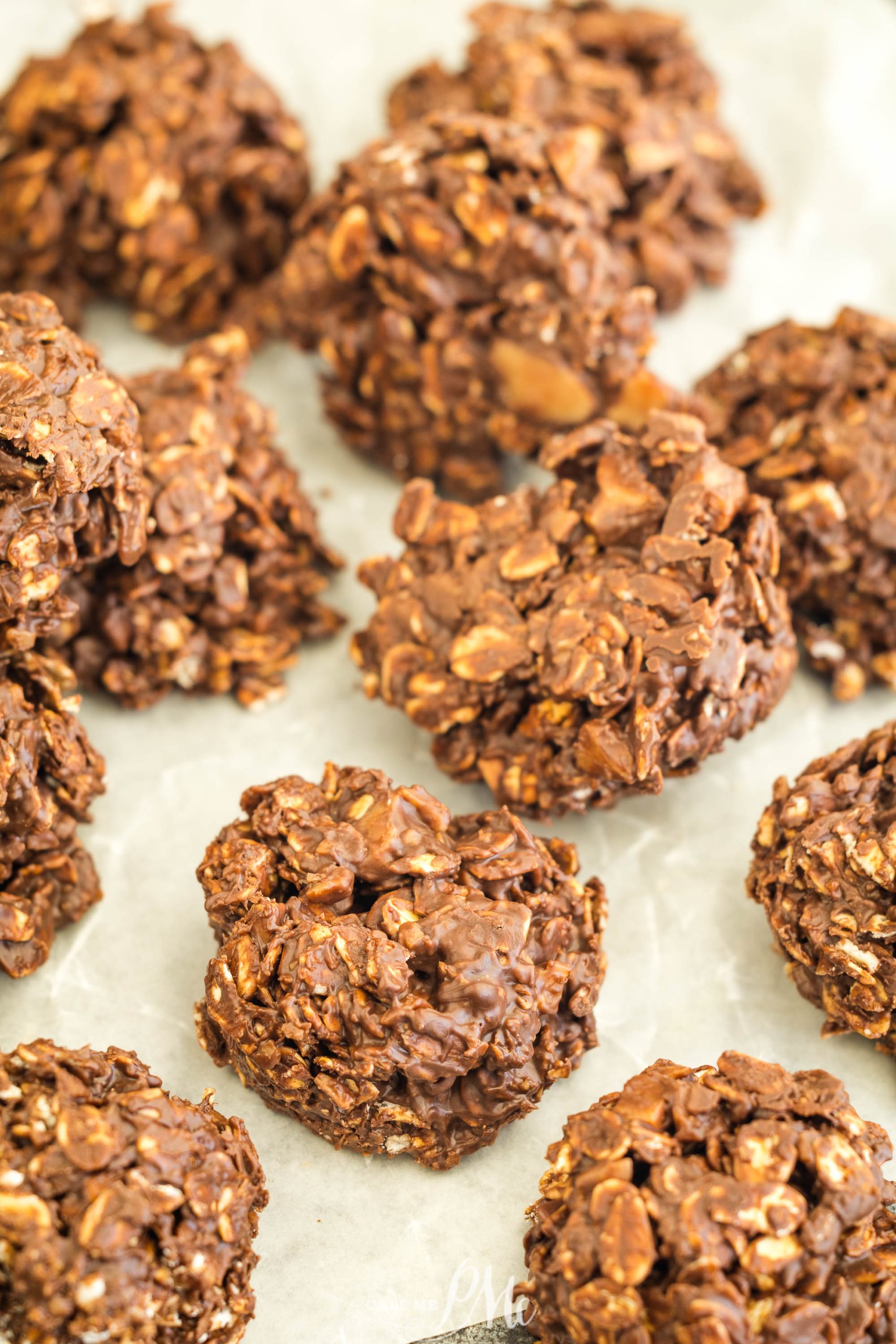 A tray of no-bake chocolate oatmeal cookies on parchment paper.