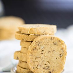 A stack of round, nut-filled cookies on a small white plate.