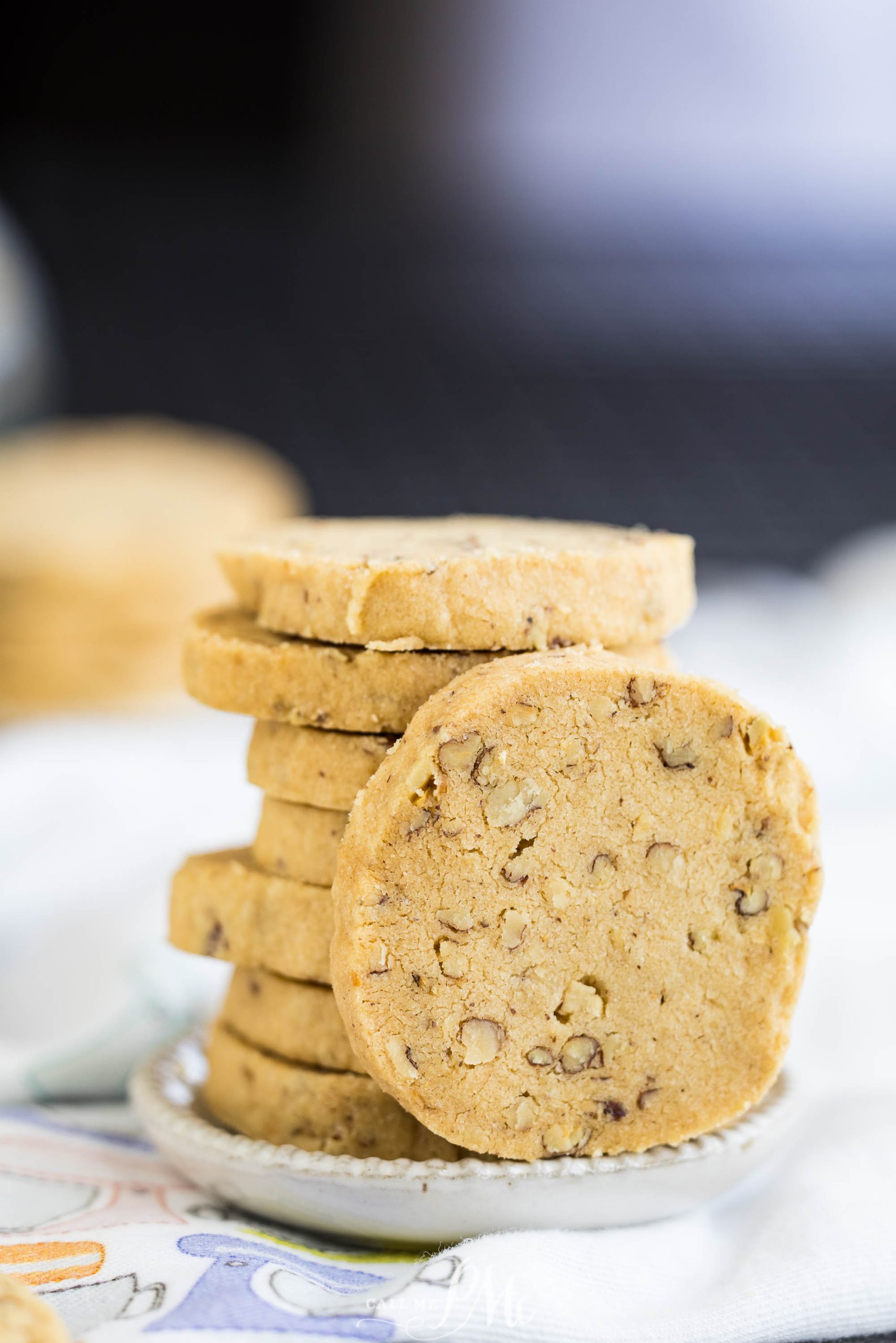 A stack of round, nut-filled cookies on a small white plate.