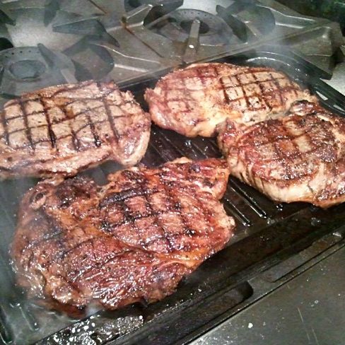 Ribeyes on a grill.