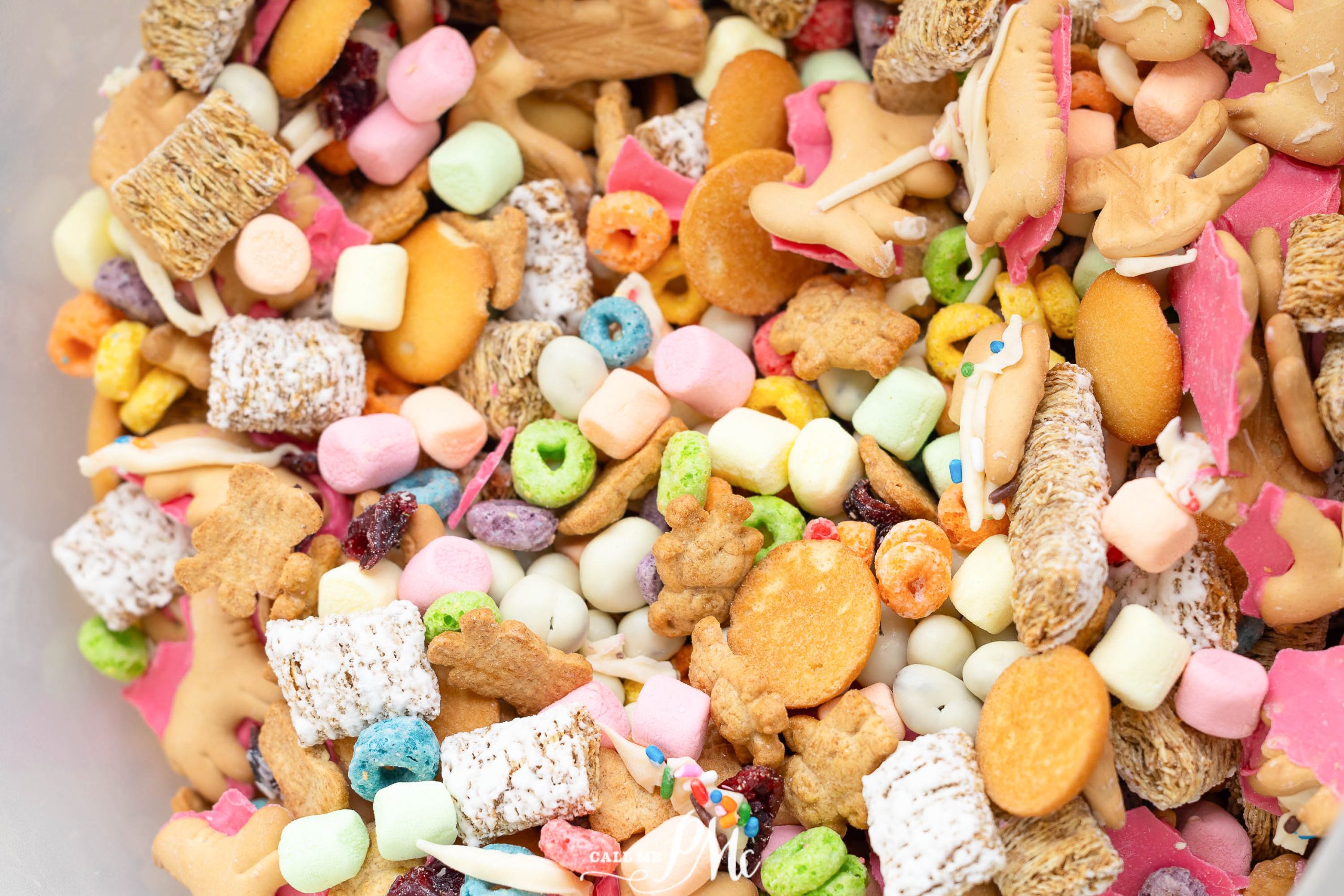 A colorful assortment of various cereals, animal crackers, mini marshmallows, and small candies mixed together.