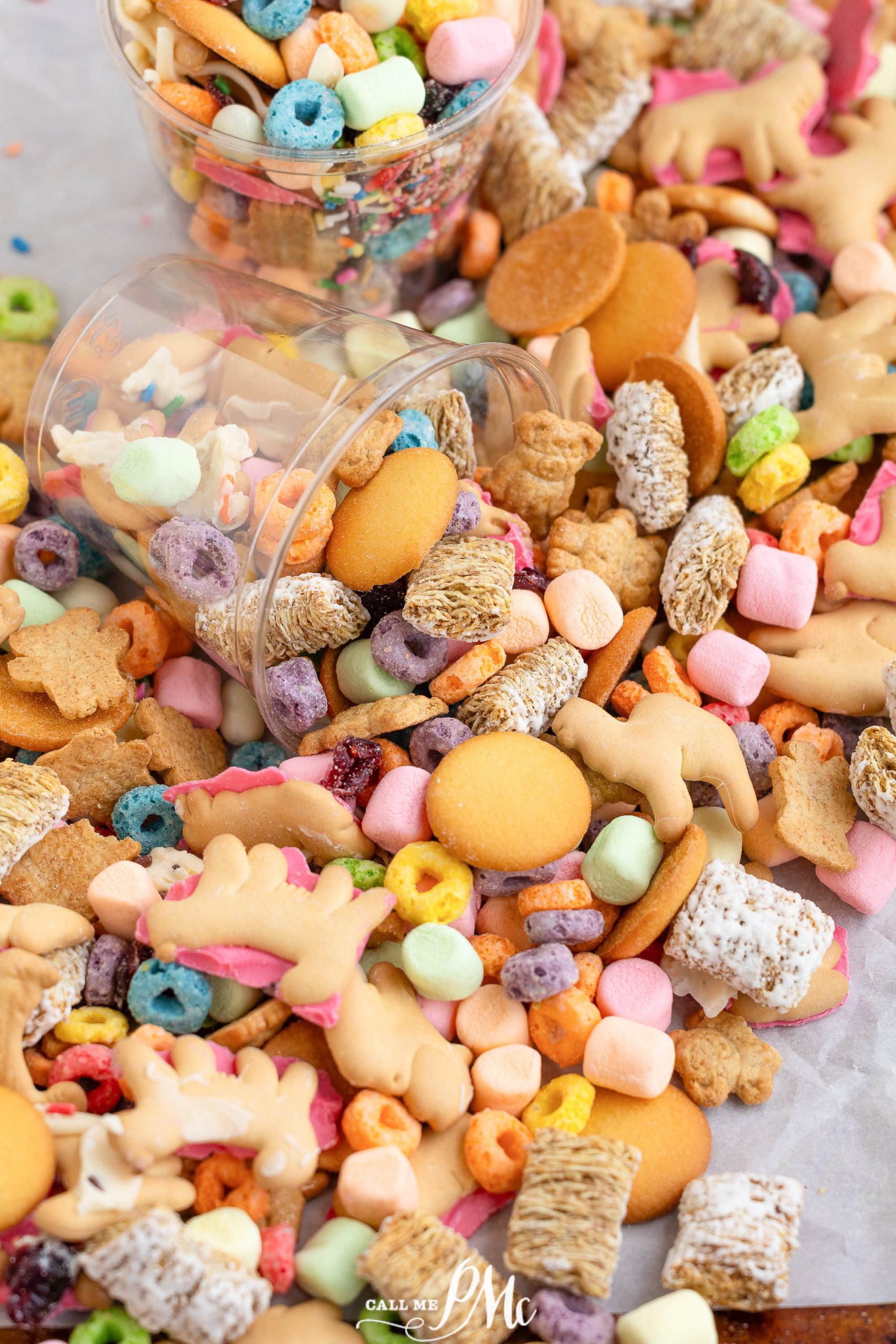 An assortment of colorful cereals, animal crackers, and cookies spilling from a container.