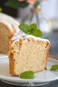 A slice of glazed sweet potato pound cake garnished with fresh mint on a white plate.