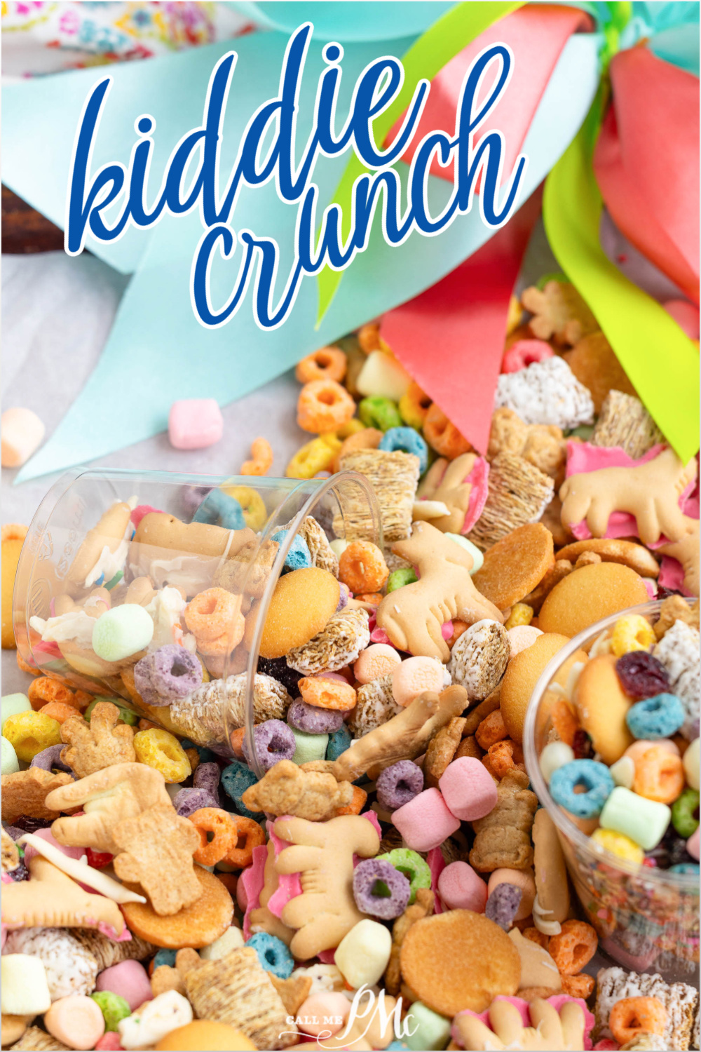 Close-up of Kiddie Crunch Snack Mix featuring animal crackers, cereal, marshmallows, and cookies spilling from cups. Multicolored ribbons decorate the background.