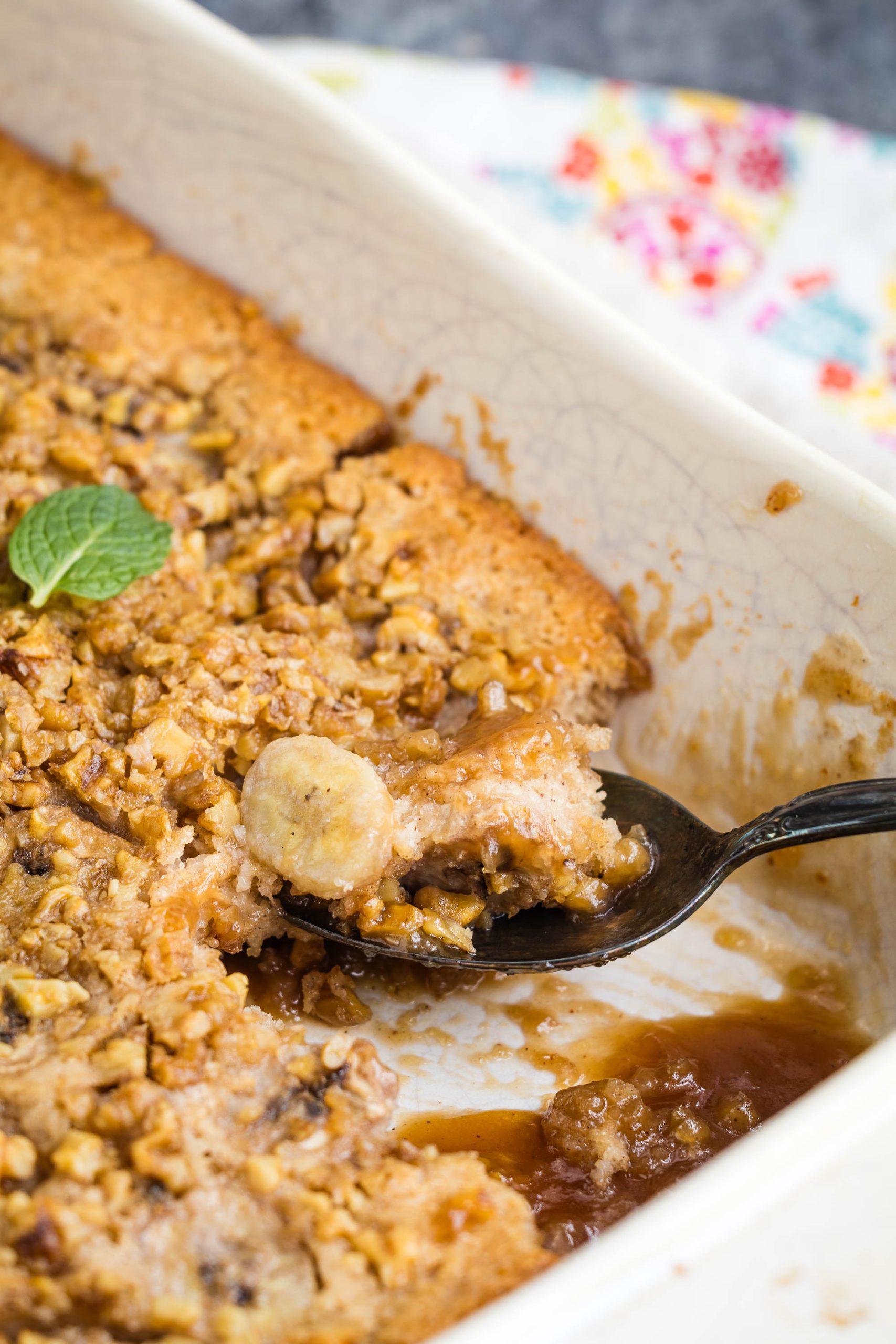 Close-up of a partially eaten baked dish with a crumbly topping in a white baking dish, fea