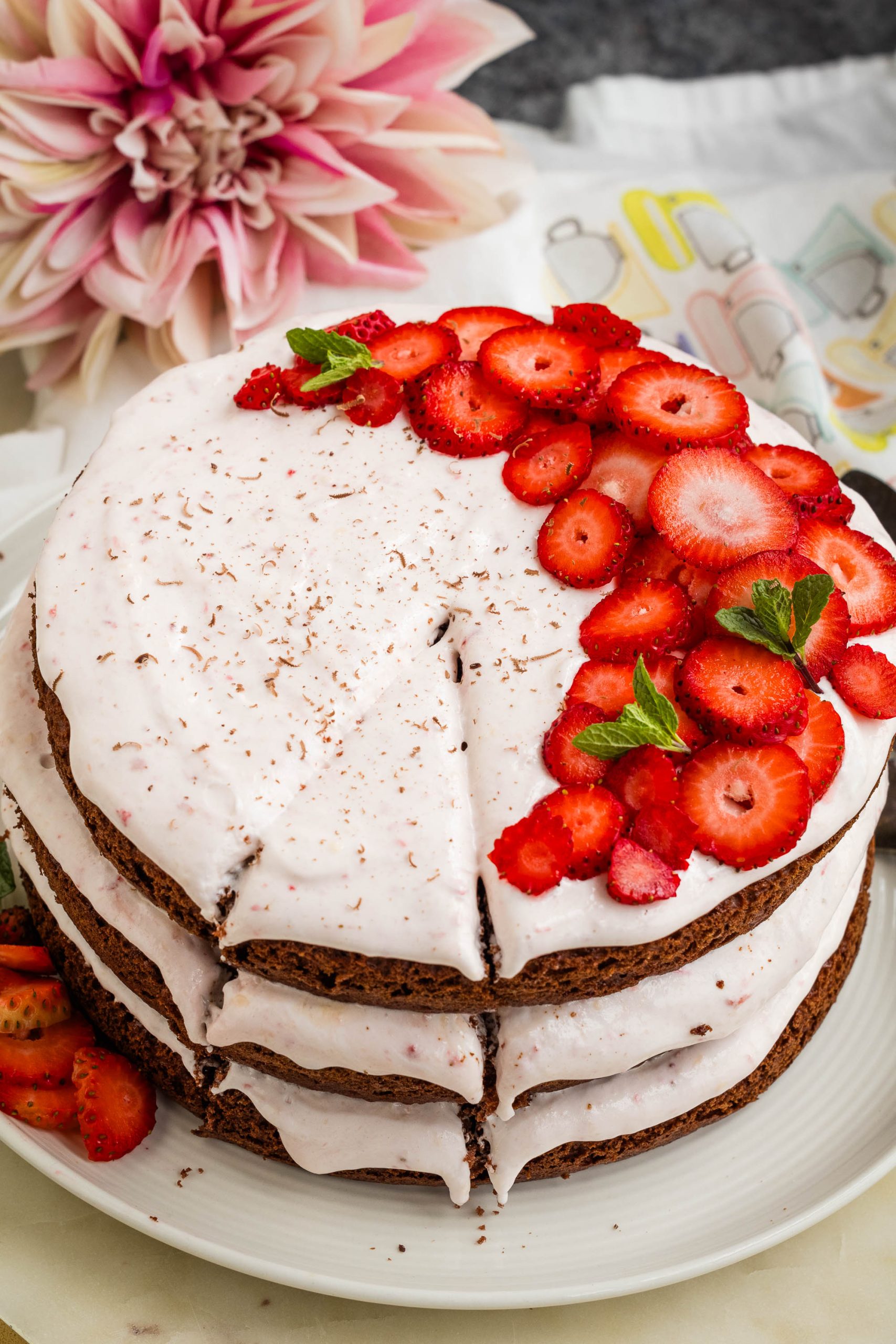 Dessert topped and partially garnished with mint leaves against a floral backdrop.