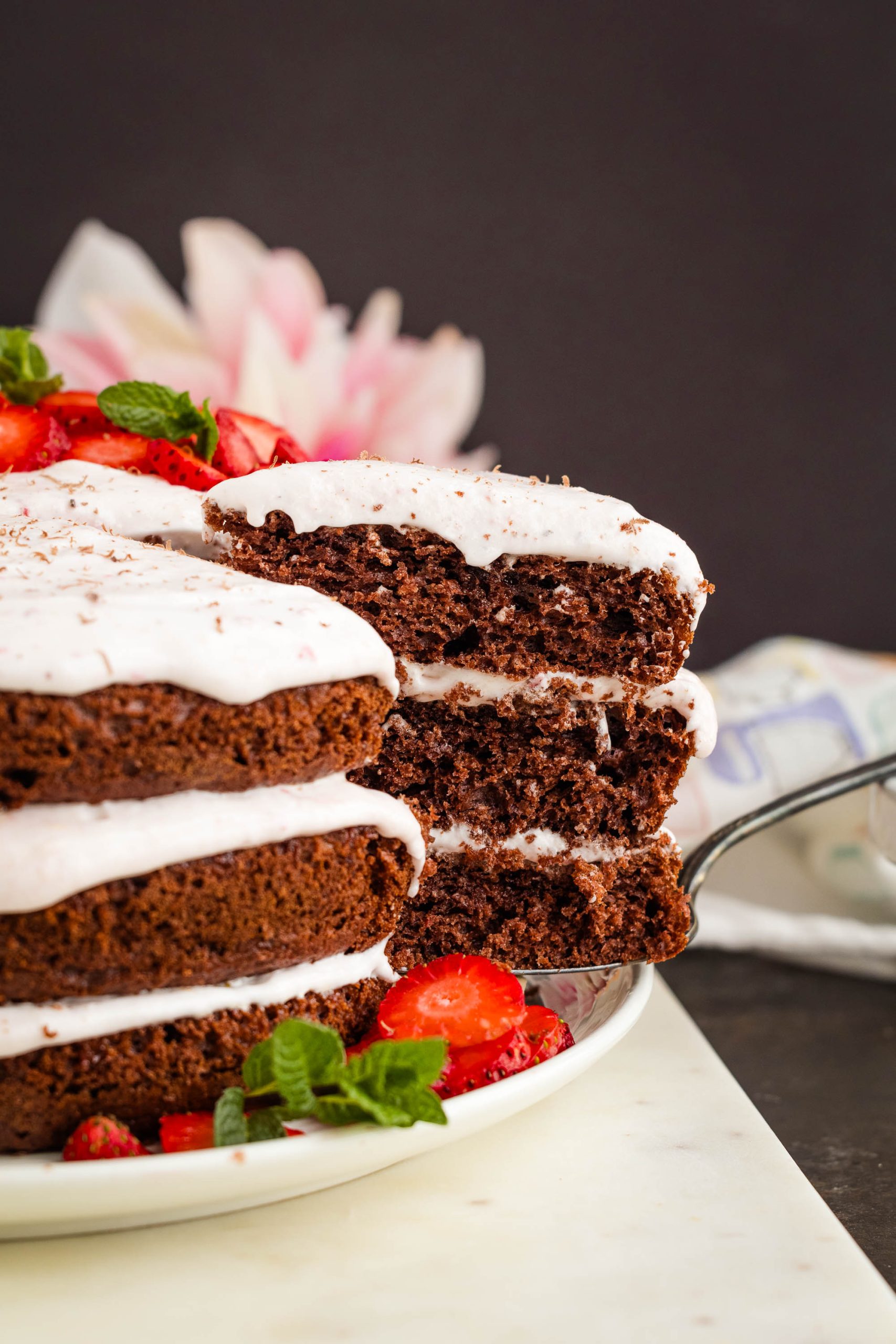 Dessert, partially sliced, on a white plate with a floral background.